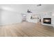 Bright and spacious living room with wood-look floors and a fireplace, flowing into the modern kitchen at 8320 Deer Springs Way, Las Vegas, NV 89149