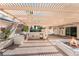 Inviting outdoor kitchen with pergola, BBQ grill, mini fridge, and cozy fire pit, perfect for entertaining at 8320 Deer Springs Way, Las Vegas, NV 89149