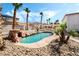 Inviting pool area with rock waterfall feature, landscaping, and an outdoor kitchen for Gathering fun at 8320 Deer Springs Way, Las Vegas, NV 89149