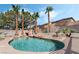 Sparkling swimming pool featuring tropical palm trees, rock features, and beautiful landscaping for a resort-style backyard at 8320 Deer Springs Way, Las Vegas, NV 89149