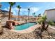 Inviting pool area with rock waterfall feature, landscaping, and an outdoor kitchen for Gathering fun at 8320 Deer Springs Way, Las Vegas, NV 89149