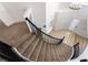 Elegant curved staircase with black wrought iron railing, plush carpet, and natural light from the front entry at 8320 Deer Springs Way, Las Vegas, NV 89149