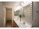 Well-lit bathroom with double sinks, vanity, decorative mirrors, and a walk-in closet at 8555 W Russell Rd # 2020, Las Vegas, NV 89113