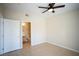Bright, neutral bedroom featuring tile floor, ceiling fan, and access to the ensuite bathroom at 8555 W Russell Rd # 2020, Las Vegas, NV 89113