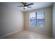 Neutral-toned bedroom features tile flooring, a ceiling fan, and a sun-filled window at 8555 W Russell Rd # 2020, Las Vegas, NV 89113