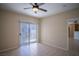 Bright bedroom featuring neutral walls, ceiling fan, tile flooring, and sliding door access to outdoor balcony at 8555 W Russell Rd # 2020, Las Vegas, NV 89113