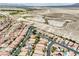Scenic aerial view of a well-planned residential community, with pools, solar panels, and landscaping bordering the desert at 8836 Martin Downs Pl, Las Vegas, NV 89131