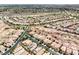 Sweeping aerial view highlighting a vast residential area with winding streets and well-kept homes in a desert landscape at 8836 Martin Downs Pl, Las Vegas, NV 89131