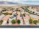 Aerial view of a neighborhood with desert landscaping, solar panels, and beautiful mountain views at 8836 Martin Downs Pl, Las Vegas, NV 89131