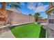 The backyard offers a manicured lawn area, seating area, tall palm tree, and brick perimeter wall at 8836 Martin Downs Pl, Las Vegas, NV 89131