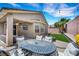 The backyard offers a covered patio, seating area, palm trees, and low-maintenance landscaping at 8836 Martin Downs Pl, Las Vegas, NV 89131