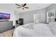 Bright primary bedroom with hardwood floors, large bed, TV, and an ensuite bathroom at 8836 Martin Downs Pl, Las Vegas, NV 89131