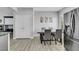 Charming dining area adjacent to kitchen with modern table set and stainless steel refrigerator at 8836 Martin Downs Pl, Las Vegas, NV 89131