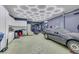 Spacious garage featuring a custom ceiling light fixture, TV, and plenty of storage at 8836 Martin Downs Pl, Las Vegas, NV 89131