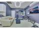 Garage with a white leather couch, tv, and workout equipment at 8836 Martin Downs Pl, Las Vegas, NV 89131