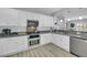 Well-lit kitchen with granite countertops, stainless steel appliances, and white cabinetry at 8836 Martin Downs Pl, Las Vegas, NV 89131