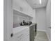Modern laundry room featuring stainless steel washer and dryer and ample counter space at 8836 Martin Downs Pl, Las Vegas, NV 89131