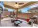 This covered patio features a ceiling fan, TV, seating area, and grill at 8836 Martin Downs Pl, Las Vegas, NV 89131