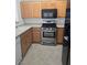 Kitchen showcasing stainless steel oven, wood cabinets and granite countertops at 8985 S Durango Dr # 1154, Las Vegas, NV 89113