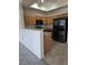 Kitchen featuring wood cabinets, black appliances, and neutral countertops at 8985 S Durango Dr # 1154, Las Vegas, NV 89113