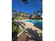 Community pool with lush palm trees and lounge seating under a clear sky at 8985 S Durango Dr # 1154, Las Vegas, NV 89113