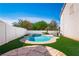 Backyard featuring a pristine pool, spa, manicured turf, and beautiful stone tile flooring at 1011 Pearl Marble Ave, North Las Vegas, NV 89081