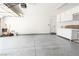 This garage has epoxy flooring, shelving, and a door to enter into the house at 1011 Pearl Marble Ave, North Las Vegas, NV 89081