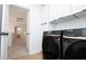 Well-equipped laundry room with Samsung washer and dryer, and white cabinets for ample storage space at 1011 Pearl Marble Ave, North Las Vegas, NV 89081