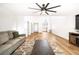 Open-concept living room with hardwood floors and a kitchen view featuring a ceiling fan at 1011 Pearl Marble Ave, North Las Vegas, NV 89081