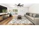 Bright living room featuring wood floors, a ceiling fan, sliding glass door, and a comfortable gray sofa at 1011 Pearl Marble Ave, North Las Vegas, NV 89081