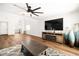 Open-concept living room with a large ceiling fan, hardwood floors, and natural light at 1011 Pearl Marble Ave, North Las Vegas, NV 89081