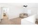 Open loft area featuring neutral carpet, a ceiling fan, and view of the bathroom at 1011 Pearl Marble Ave, North Las Vegas, NV 89081
