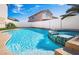 Inviting backyard pool and spa combination with mature plants and a white fence at 1011 Pearl Marble Ave, North Las Vegas, NV 89081