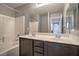 Bathroom featuring a double sink vanity, bathtub, and shower combination with white tile surround at 10116 Nash Peak Ave, Las Vegas, NV 89166