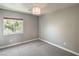 Neutral bedroom featuring gray walls, plush carpeting, a window, and modern light fixture at 10116 Nash Peak Ave, Las Vegas, NV 89166