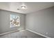 Bright bedroom featuring plush carpet, neutral walls, and a large window with neighborhood views at 10116 Nash Peak Ave, Las Vegas, NV 89166