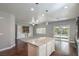 Open kitchen and living area with granite island, custom cabinets, stainless appliances, and sliding door access to the backyard at 10116 Nash Peak Ave, Las Vegas, NV 89166
