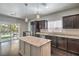 Modern kitchen with dark cabinets, granite countertops, an island, and stainless steel appliances at 10116 Nash Peak Ave, Las Vegas, NV 89166
