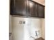 Laundry area with dark brown cabinets and utility hookups; offering practicality and organization at 10116 Nash Peak Ave, Las Vegas, NV 89166