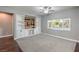 Spacious living room features custom built-ins, a rustic wood accent wall, plush carpet, and natural light from the window at 10116 Nash Peak Ave, Las Vegas, NV 89166