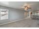 Spacious living area featuring a ceiling fan, plush carpet, and natural light from a window at 10116 Nash Peak Ave, Las Vegas, NV 89166