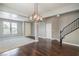 Inviting living room featuring hardwood floors, carpet, staircase, and a modern chandelier at 10116 Nash Peak Ave, Las Vegas, NV 89166