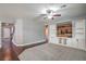 Bright living area with custom built-ins and shelving, wood-paneled wall, and neutral carpet flooring at 10116 Nash Peak Ave, Las Vegas, NV 89166