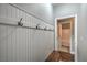 Mudroom with white wainscoting, dark coat hooks, and access to a nearby bathroom at 10116 Nash Peak Ave, Las Vegas, NV 89166