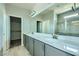 Bathroom featuring double vanity sinks, a walk-in shower, and tile backsplash at 10271 Bark Pine Ct, Las Vegas, NV 89166
