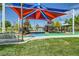 Community playground featuring a colorful shade structure and various play structures at 10271 Bark Pine Ct, Las Vegas, NV 89166