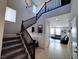 Bright foyer with staircase, neutral walls, tile floors, and view of the living room, creating an open feel at 10383 Andele Ave, Las Vegas, NV 89166