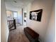 Upstairs hallway with carpet flooring and decorative artwork with a glimpse into the bedroom at 10383 Andele Ave, Las Vegas, NV 89166