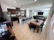 Open-concept kitchen featuring dark wood cabinets, granite counters, large island with seating, and tile flooring at 10383 Andele Ave, Las Vegas, NV 89166