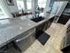 Kitchen island featuring stainless steel dishwasher, undermount sink, and granite countertops with breakfast bar seating at 10383 Andele Ave, Las Vegas, NV 89166
